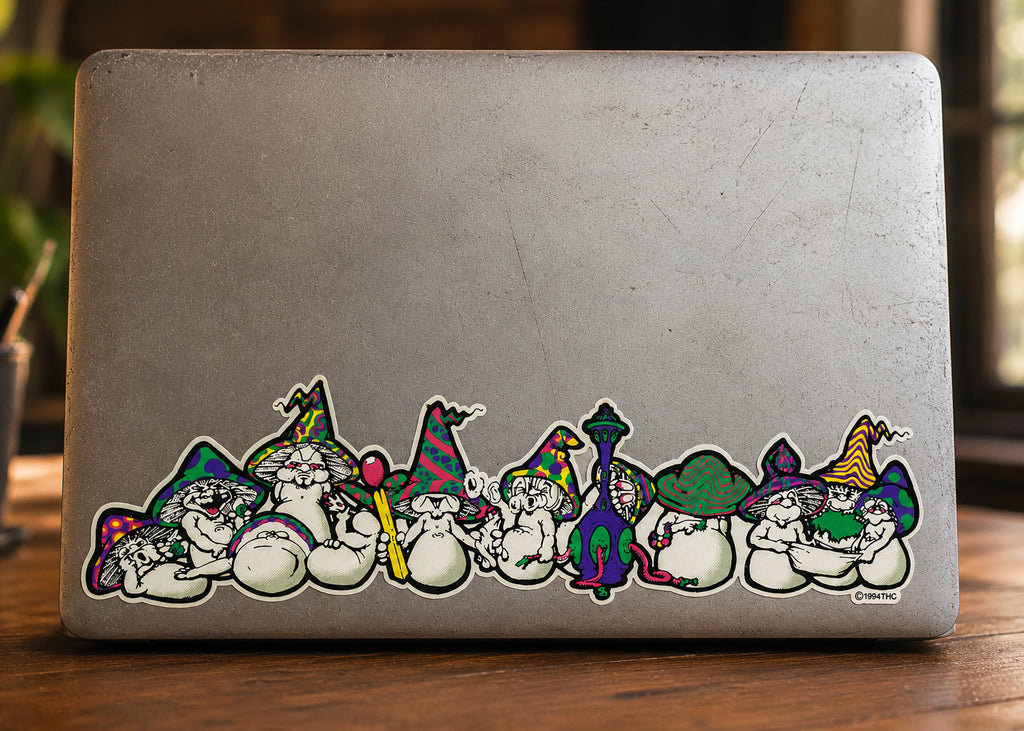 THC Mushrooms sticker stretched across bottom edge of worn laptop with scratches and multiple decals