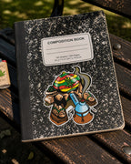 THC Rasta Joe sticker on black composition notebook on worn wooden park bench in outdoor setting