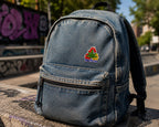 THC Recycle Leaf patch sewn onto faded denim backpack with outdoor urban setting
