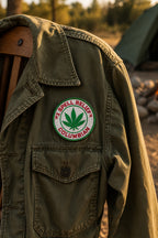 THC Columbian Patch featuring a green cannabis leaf and red embroidered lettering displayed on the chest of a vintage olive-green field jacket outdoors