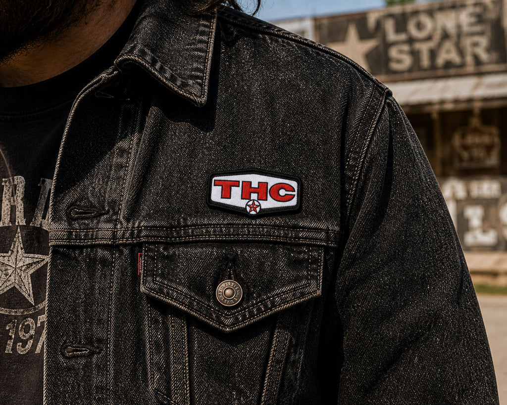 THC Lone Star patch sewn onto black denim jacket chest pocket with worn vintage texture