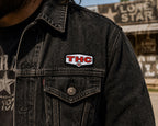 THC Lone Star patch sewn onto black denim jacket chest pocket with worn vintage texture