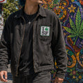 THC Leaf SF Patch displayed on the chest pocket of a black canvas jacket worn in San Francisco’s Haight-Ashbury neighborhood, featuring an embroidered cannabis leaf in a classic San Francisco-inspired design