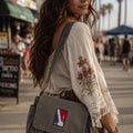THC NBA Patch displayed on a gray canvas satchel carried by a woman at the beach, featuring a bold red, white, and blue embroidered sports-inspired design
