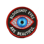 THC Bloodshot Patch featuring an embroidered blue eye with red and white detailing and the phrase “Bloodshot Eyes Are Beautiful” on a black circular background.