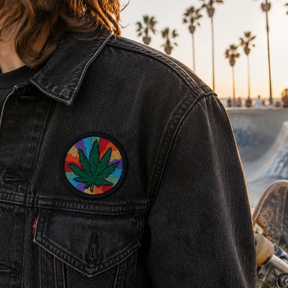 THC Rainbow Leaf embroidered patch with green cannabis leaf over psychedelic rainbow swirl background on black border