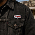 THC Lone Star patch sewn onto black denim jacket chest pocket with worn vintage texture