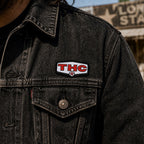 THC Lone Star patch sewn onto black denim jacket chest pocket with worn vintage texture