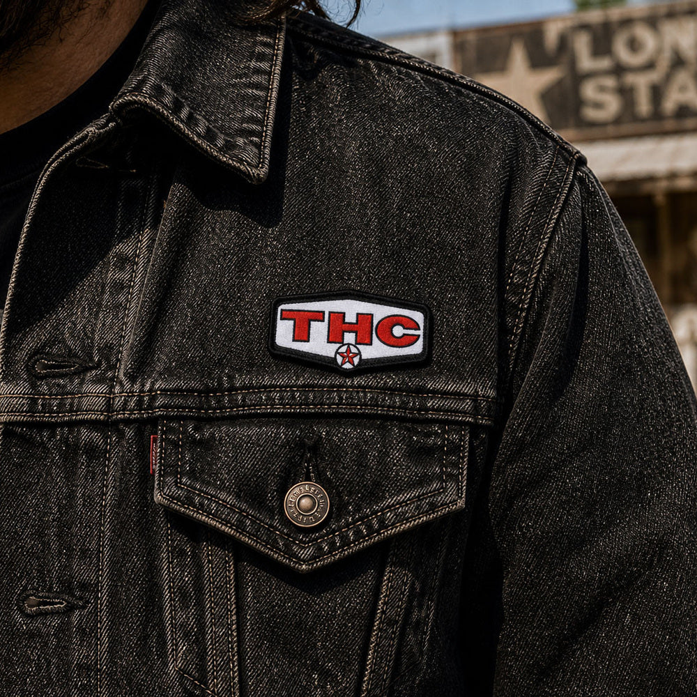 THC Lone Star patch sewn onto black denim jacket chest pocket with worn vintage texture