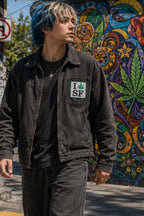 THC Leaf SF Patch displayed on the chest pocket of a black canvas jacket worn in San Francisco’s Haight-Ashbury neighborhood, featuring an embroidered cannabis leaf in a classic San Francisco-inspired design